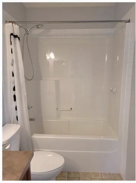 Calgary bathroom before: dated tub and surround with a shower curtain