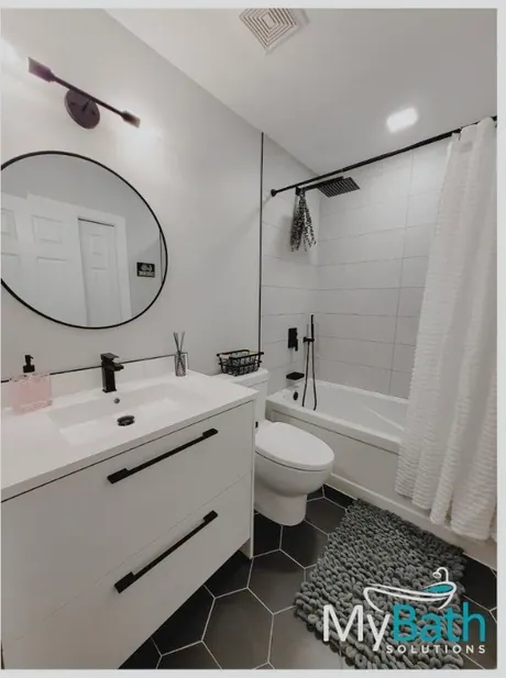 The same Calgary bathroom after: tile-less walls, new vanity and black fixtures