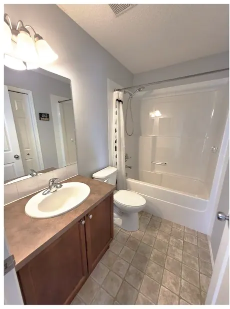 Calgary bathroom before: dated fibreglass tub surround and beige floor tile