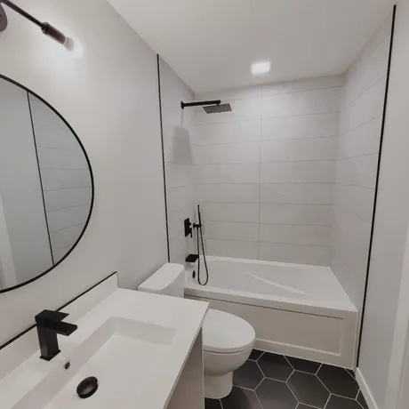 Full bathroom with a round mirror and hex-pattern floor, Calgary