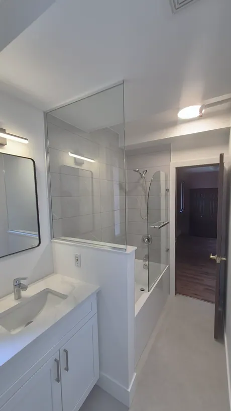 Full bathroom with vanity, tub and a fixed glass panel, Calgary