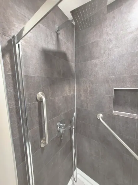 Barrier-free shower with grab bars, rain head and dark slate-look walls, Calgary