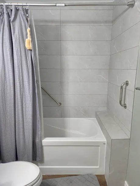 Bathtub with grey marble-look surround and a bench seat, Calgary