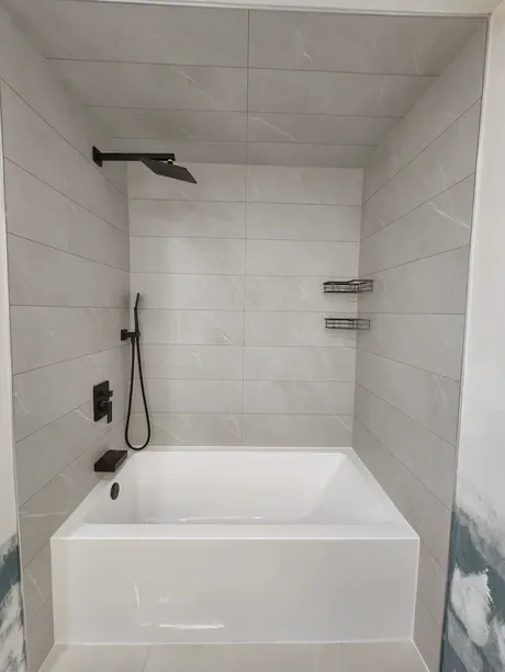 New bathtub with grey marble-look walls and black fixtures, Calgary