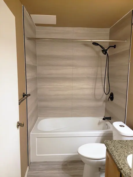Bathtub with wood-look panels and a granite-top vanity, Calgary